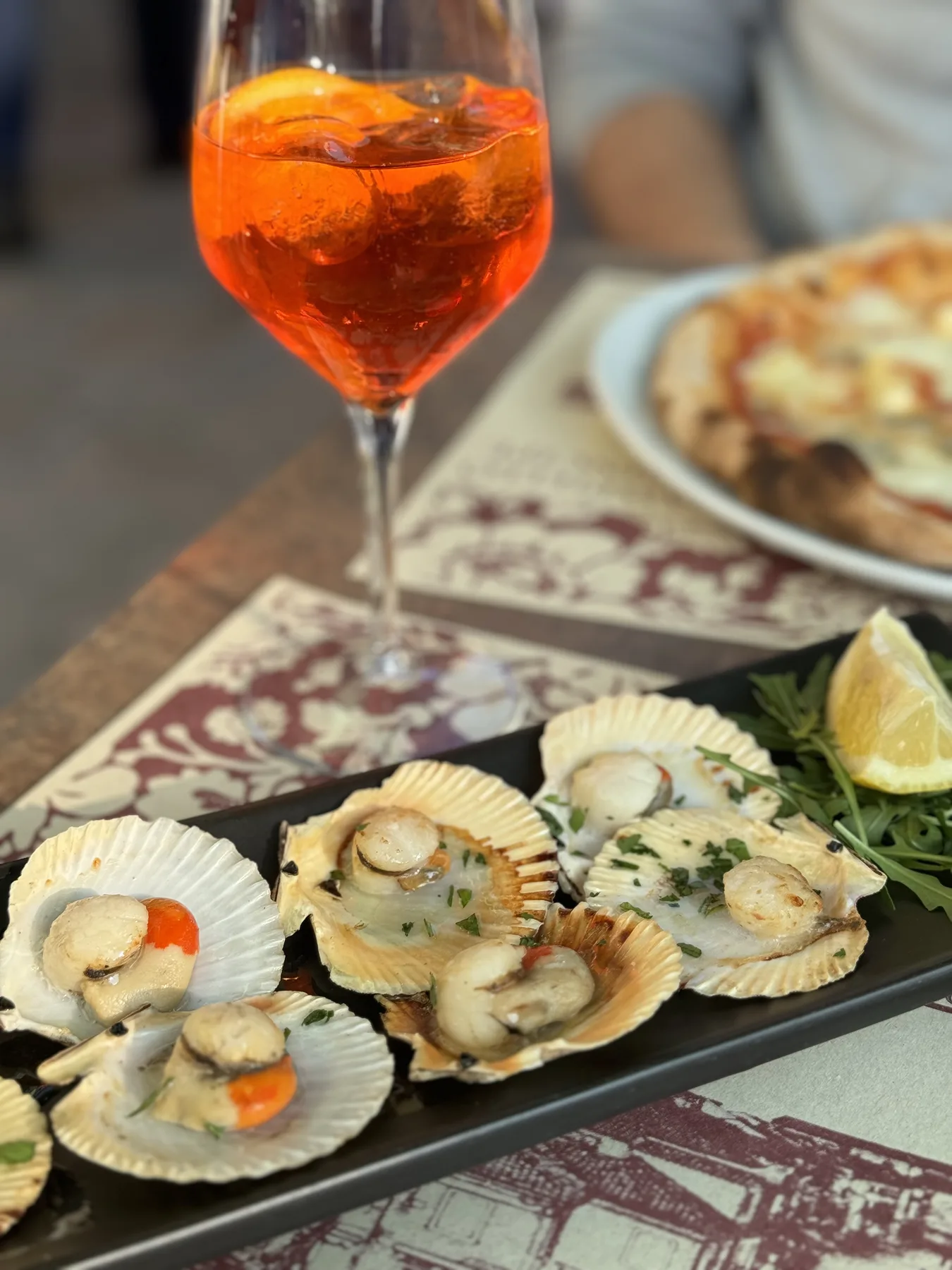Aperitivo and scallops at a restaurant table